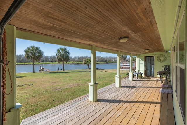 wooden deck featuring a water view and a lawn