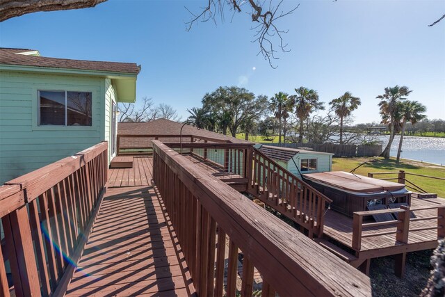 wooden deck featuring a water view and a hot tub