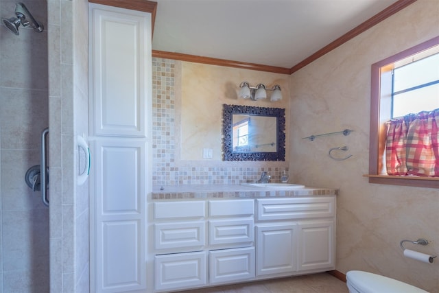 bathroom with tasteful backsplash, a shower with door, crown molding, toilet, and vanity