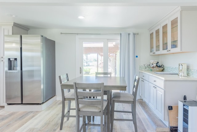 dining space with light wood-style flooring, recessed lighting, and baseboards