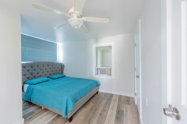 bedroom with cooling unit, baseboards, wood finished floors, and a ceiling fan