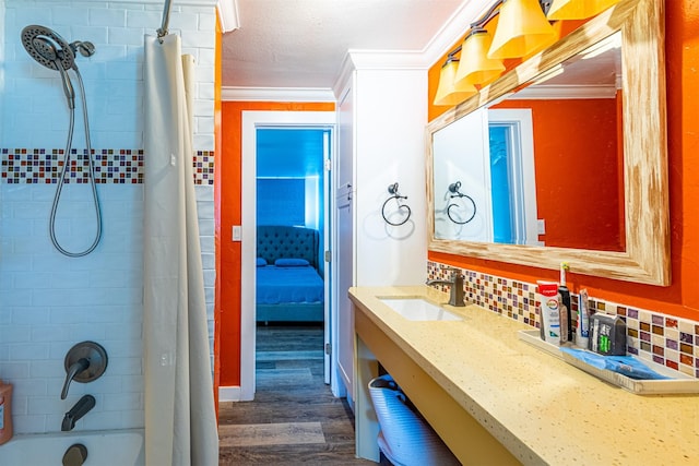 full bathroom featuring shower / bath combo, backsplash, wood finished floors, crown molding, and vanity