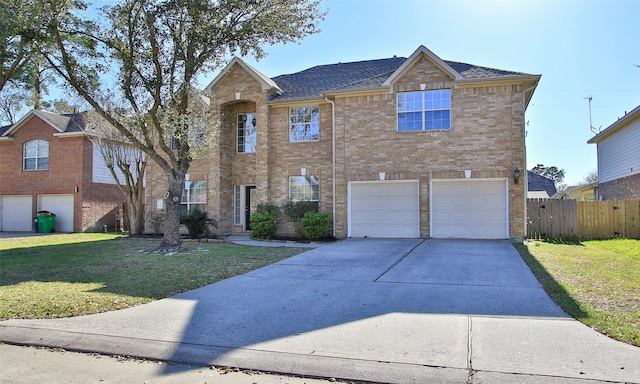 traditional home with a front lawn, driveway, fence, a garage, and brick siding