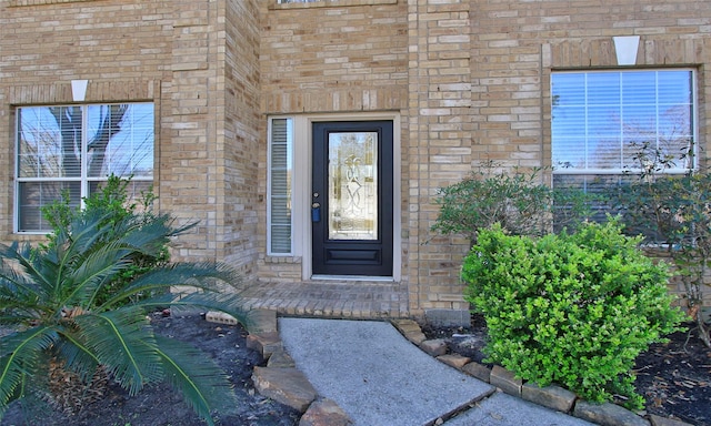 view of exterior entry with brick siding