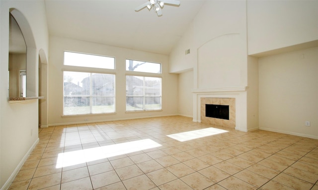 unfurnished living room featuring visible vents, high vaulted ceiling, light tile patterned flooring, ceiling fan, and a tiled fireplace