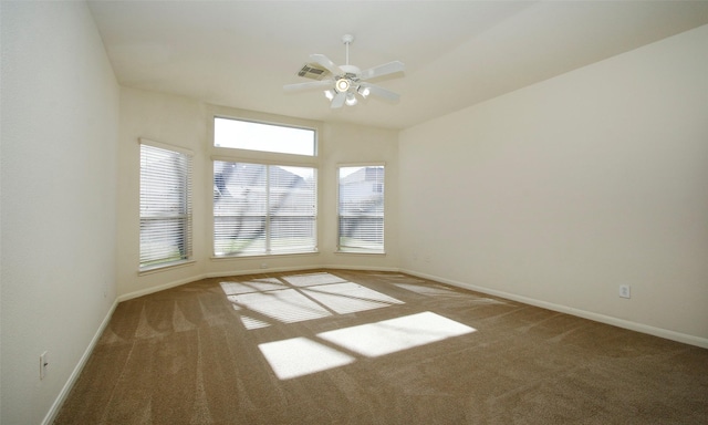 spare room featuring visible vents, carpet flooring, a ceiling fan, and baseboards