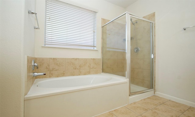 bathroom with tile patterned flooring, a bath, and a stall shower