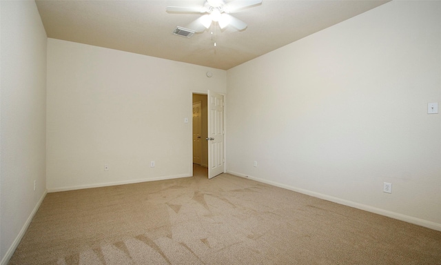 spare room with light carpet, visible vents, baseboards, and a ceiling fan