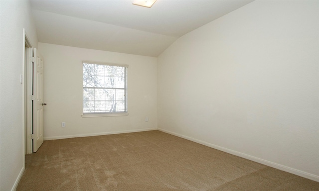 unfurnished room featuring baseboards, light colored carpet, and vaulted ceiling