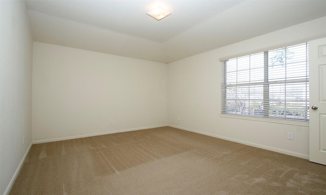 unfurnished room featuring baseboards and light carpet