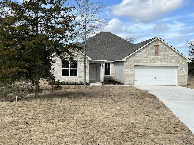 view of front of property featuring roof with shingles, concrete driveway, and an attached garage