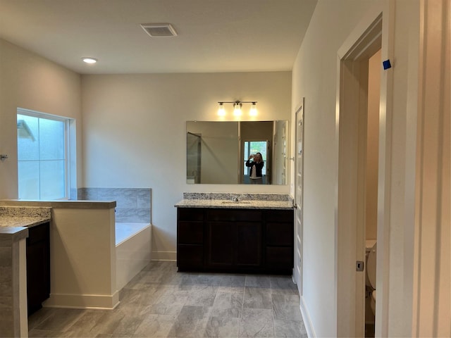 bathroom with a bath, visible vents, vanity, and walk in shower