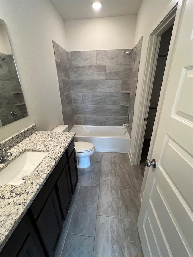 bathroom featuring toilet, vanity, and  shower combination