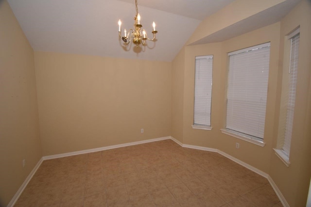 empty room featuring baseboards, lofted ceiling, and a chandelier