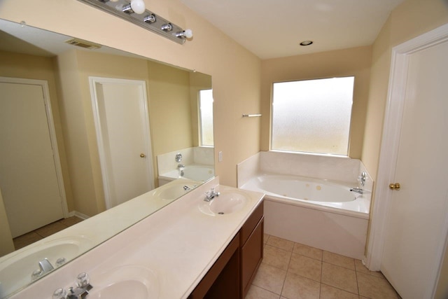 bathroom with visible vents, double vanity, a sink, a garden tub, and tile patterned floors