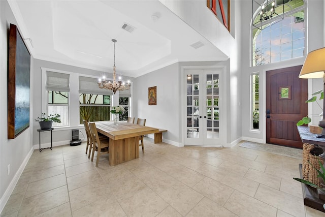 dining area featuring light tile patterned floors, baseboards, french doors, a raised ceiling, and a chandelier