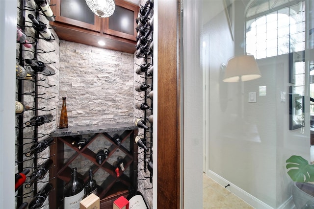 wine room featuring light tile patterned floors and baseboards