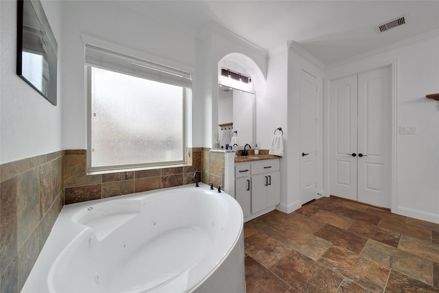 bathroom featuring visible vents, vanity, stone finish flooring, and a whirlpool tub