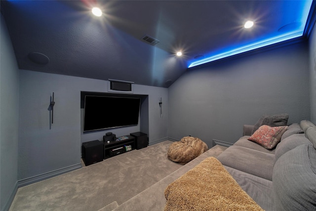 carpeted cinema room featuring visible vents, baseboards, and vaulted ceiling