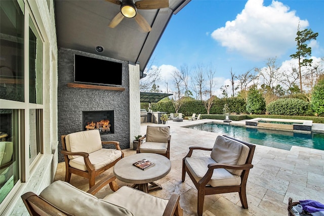 view of patio featuring a pool with connected hot tub, a ceiling fan, and an outdoor living space with a fireplace