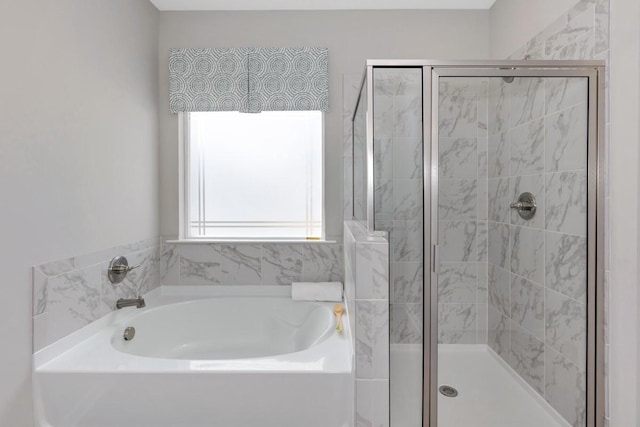 bathroom with a shower stall and a bath