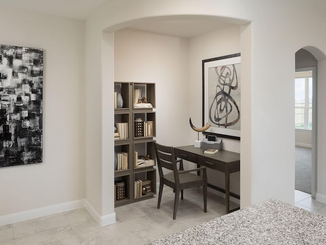 home office featuring arched walkways and baseboards