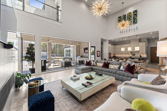 living area featuring recessed lighting, an inviting chandelier, and a towering ceiling