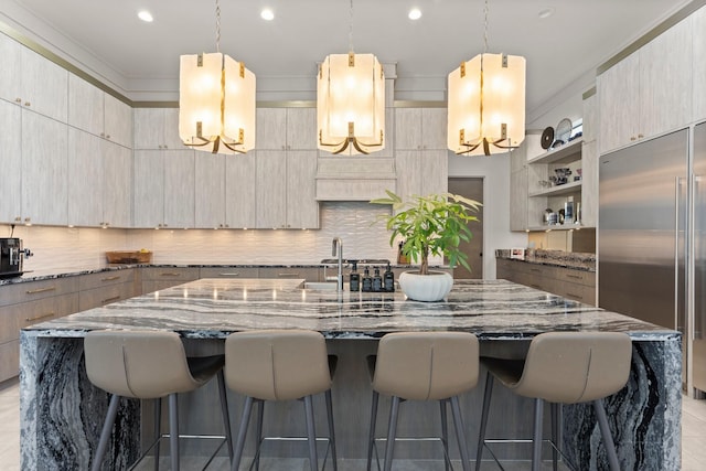 kitchen with light stone counters, modern cabinets, and built in fridge