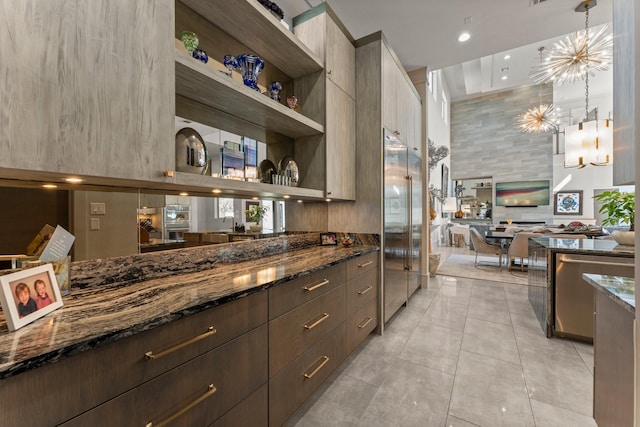 kitchen with modern cabinets, dark stone counters, and appliances with stainless steel finishes