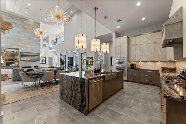 kitchen featuring visible vents, dark stone countertops, appliances with stainless steel finishes, modern cabinets, and a sink