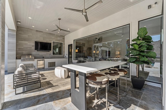 view of patio / terrace with ceiling fan, a grill, an outdoor kitchen, and outdoor dining space