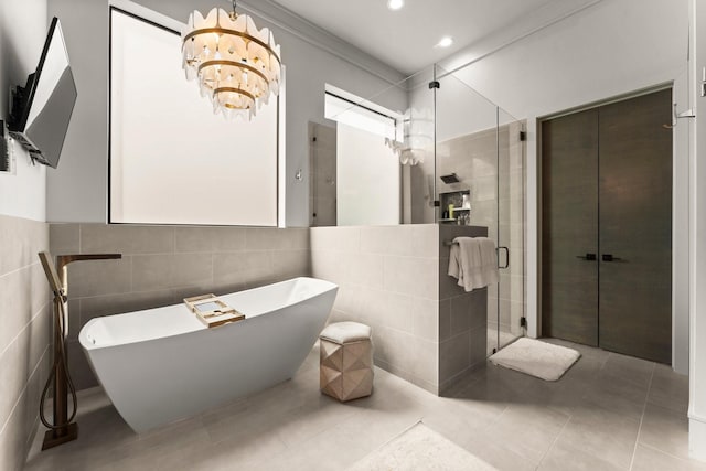 bathroom featuring tile patterned floors, a freestanding tub, tile walls, and a stall shower