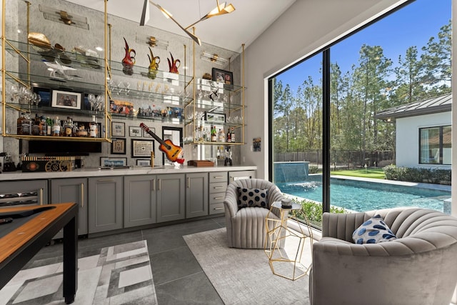 bar featuring a wealth of natural light, wet bar, and tile patterned flooring