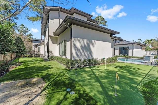 view of home's exterior with fence and stucco siding