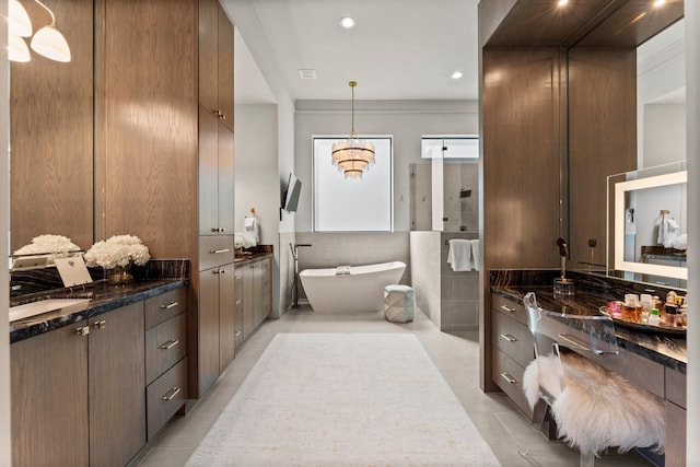 full bath featuring two vanities, recessed lighting, tile walls, tile patterned flooring, and a soaking tub