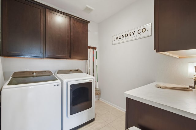 laundry area featuring visible vents, baseboards, light tile patterned floors, cabinet space, and separate washer and dryer