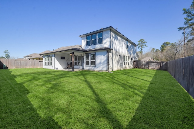 rear view of property with a yard and a fenced backyard