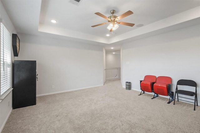 living area with recessed lighting, a tray ceiling, carpet floors, and visible vents