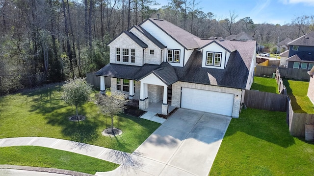 view of front facade featuring stone siding, concrete driveway, a front yard, and fence