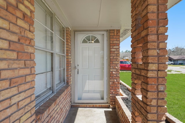 doorway to property featuring brick siding