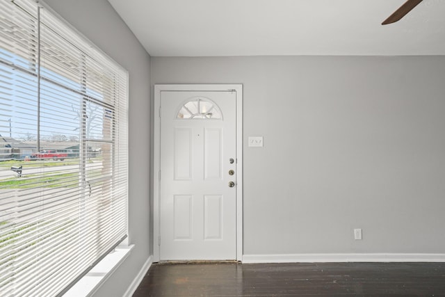 foyer entrance featuring a ceiling fan, dark wood-type flooring, and baseboards