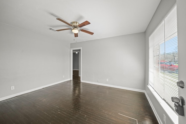 unfurnished room featuring a ceiling fan, visible vents, baseboards, and dark wood-style flooring