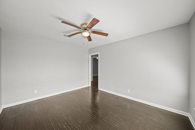 spare room with dark wood finished floors, visible vents, baseboards, and a ceiling fan