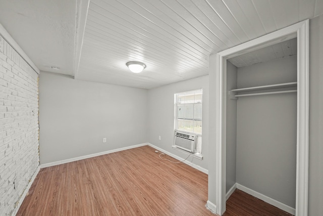 unfurnished bedroom featuring wood finished floors, a closet, and baseboards