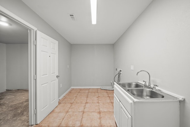 kitchen featuring visible vents, white cabinets, light countertops, and a sink