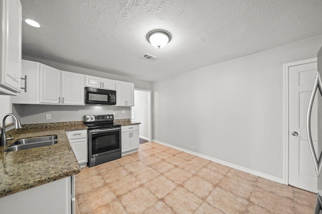 kitchen featuring visible vents, baseboards, stainless steel appliances, white cabinetry, and a sink