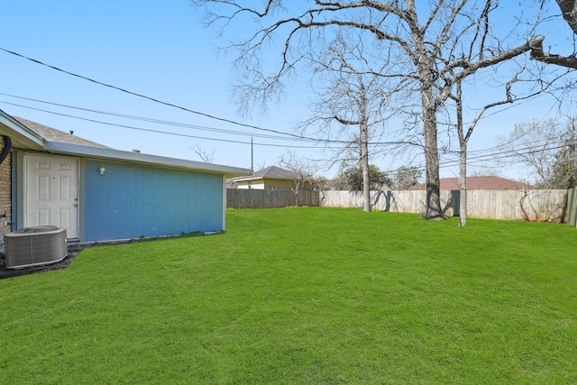 view of yard featuring central AC and fence