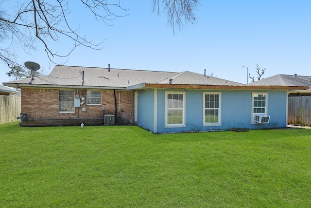 rear view of house with brick siding, fence, central AC unit, cooling unit, and a yard