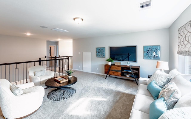 carpeted living area with baseboards and visible vents
