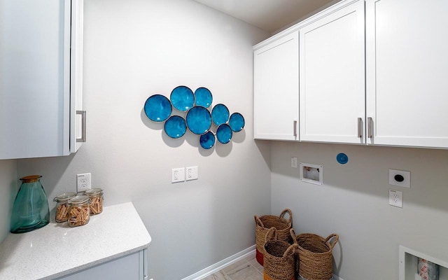 washroom with hookup for a washing machine, cabinet space, baseboards, and hookup for an electric dryer